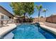 A beautiful backyard pool featuring a built-in spa and cascading waterfall, perfect for relaxation and entertaining at 12325 W Berridge Ln, Litchfield Park, AZ 85340