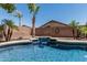 Backyard pool featuring desert landscaping, a waterfall, and clear blue water at 12325 W Berridge Ln, Litchfield Park, AZ 85340
