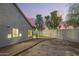 Side view of backyard featuring lush green grass, block fence, and glimpse of home during the sunset at 1405 N Jamaica Way, Gilbert, AZ 85234