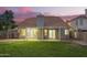 Spacious backyard featuring lush green grass, block fence, patio, and a glimpse of the home at dusk at 1405 N Jamaica Way, Gilbert, AZ 85234