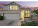 This two-story home features a tile roof, a well-manicured lawn, and large windows at 1405 N Jamaica Way, Gilbert, AZ 85234