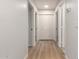 Hallway with wood-look flooring, white walls, and multiple doorways at 1405 N Jamaica Way, Gilbert, AZ 85234
