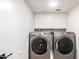 Bright laundry room featuring front loading washer and dryer with ample cabinet space above at 1405 N Jamaica Way, Gilbert, AZ 85234