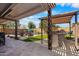 An outdoor living space with a built-in outdoor kitchen, pool, lounge chairs, and a covered patio at 1432 E Penny Ln, San Tan Valley, AZ 85140