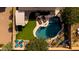 Birds-eye view of a backyard with a pool, pergola-covered patio, artificial turf, and desert landscaping at 1432 E Penny Ln, San Tan Valley, AZ 85140