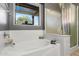 Relaxing bathtub with tile surround and a view to the backyard, complemented by a glass shower enclosure at 1432 E Penny Ln, San Tan Valley, AZ 85140