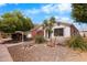 A beautiful white single-story house with desert landscaping, rock accents, and mature trees at 1432 E Penny Ln, San Tan Valley, AZ 85140