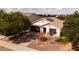 Aerial view of a charming home with a desert landscape, a two-car garage, and solar panels at 1432 E Penny Ln, San Tan Valley, AZ 85140