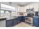 A modern kitchen featuring white subway tile, two-tone cabinetry, and stainless steel appliances at 1432 E Penny Ln, San Tan Valley, AZ 85140