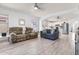 Open-concept living room featuring neutral tones, hardwood floors, and two sofas with an archway into the kitchen at 1432 E Penny Ln, San Tan Valley, AZ 85140