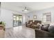 Bright living room featuring wood-look floors, a ceiling fan, and a sliding glass door to the patio at 1432 E Penny Ln, San Tan Valley, AZ 85140