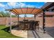 Outdoor kitchen featuring bar seating, stone countertop, and covered patio, perfect for entertaining with friends at 1432 E Penny Ln, San Tan Valley, AZ 85140