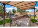 Outdoor kitchen featuring a built-in barbeque grill, covered patio, stone countertops, and bar seating overlooking the pool at 1432 E Penny Ln, San Tan Valley, AZ 85140