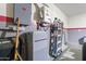 Utility room with water heater, fuse box, ladder, shelving, and painted accents, offering essential home systems at 1432 E Penny Ln, San Tan Valley, AZ 85140