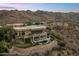 Aerial view of luxury home with pool, putting green, and expansive outdoor living spaces nestled in the desert landscape at 15054 E Sundown Dr, Fountain Hills, AZ 85268