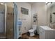 Cozy bathroom featuring a glass-enclosed shower, floating shelves, earth-toned tile and a decorative mirror at 15054 E Sundown Dr, Fountain Hills, AZ 85268