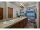 This bathroom features double sinks, a tile countertop, wood cabinets, and vanity lighting at 15054 E Sundown Dr, Fountain Hills, AZ 85268