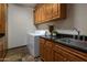 A convenient laundry room with granite countertops, stainless steel sink, washer, dryer, and wood cabinets at 15054 E Sundown Dr, Fountain Hills, AZ 85268