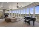 Bright living room featuring a stone fireplace, large windows with mountain views, and a grand piano at 15054 E Sundown Dr, Fountain Hills, AZ 85268