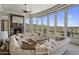 Bright living room featuring a stone fireplace, large windows with mountain views and a curved sofa at 15054 E Sundown Dr, Fountain Hills, AZ 85268