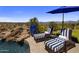 Relaxing poolside lounge area with comfortable chairs and a patio umbrella, offering stunning views at 15054 E Sundown Dr, Fountain Hills, AZ 85268