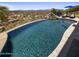 Stunning infinity pool with rock waterfall feature, surrounded by lush landscaping and offering expansive views at 15054 E Sundown Dr, Fountain Hills, AZ 85268