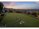 Backyard putting green featuring artificial turf, multiple holes, lighting and stunning sunset views at 15054 E Sundown Dr, Fountain Hills, AZ 85268