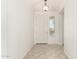 Bright entryway featuring tiled flooring, a white front door with sidelight window, and a modern light fixture at 15429 W Ventura St, Surprise, AZ 85379