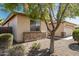 Tan home featuring stone accents, a well-manicured yard, and mature trees providing ample shade at 15429 W Ventura St, Surprise, AZ 85379