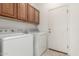 Laundry room offers cabinetry, appliances, and tile flooring at 15429 W Ventura St, Surprise, AZ 85379