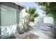 View of backyard with a shed, open garage, and a paved area, shaded by a tree at 1609 W Lewis Ave, Phoenix, AZ 85007