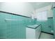 Vintage bathroom with turquoise tiles, a white sink vanity, and natural light at 1609 W Lewis Ave, Phoenix, AZ 85007