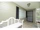 Inviting front porch with bench and secure gate entrance, black shutters, and painted brick at 1609 W Lewis Ave, Phoenix, AZ 85007