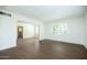 Clean, bright room with hardwood floors and an arched opening to another room at 1609 W Lewis Ave, Phoenix, AZ 85007
