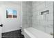 Renovated bathroom features white marble tile and window view at 1621 W Mulberry Dr, Phoenix, AZ 85015