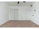 Carpeted bedroom features a ceiling fan, closet, and entry door at 1621 W Mulberry Dr, Phoenix, AZ 85015
