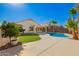 Beautiful backyard featuring pool, palm trees, and lawn at 17649 N Vera Cruz Ave, Maricopa, AZ 85139