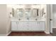 Modern bathroom featuring a double sink vanity with marble countertop and three wall mirrors at 17649 N Vera Cruz Ave, Maricopa, AZ 85139