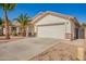 View of home's exterior showcasing an attached two-car garage and desert landscaping with decorative stone at 17649 N Vera Cruz Ave, Maricopa, AZ 85139