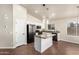 Stylish kitchen with granite countertops, a central island, and stainless steel appliances, seamlessly connecting to the living area at 17649 N Vera Cruz Ave, Maricopa, AZ 85139