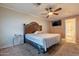 Bedroom features a ceiling fan, carpet, and an en suite bathroom at 1814 N 89Th Ave, Phoenix, AZ 85037