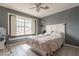 Cozy bedroom with a window, white headboard bed, and tile floors at 1814 N 89Th Ave, Phoenix, AZ 85037