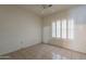 Bright bedroom featuring neutral tile flooring, ceiling fan, and window with shutter at 1814 N 89Th Ave, Phoenix, AZ 85037