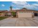 Inviting single-story home features a well-manicured lawn, mature trees, and an expansive driveway with a two-car garage at 1814 N 89Th Ave, Phoenix, AZ 85037