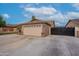 Single-story home features a well-manicured lawn, mature trees, and an expansive driveway with a two-car garage at 1814 N 89Th Ave, Phoenix, AZ 85037
