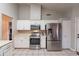 Modern kitchen features stainless steel appliances, ample counter space, and updated lighting for a sleek cooking environment at 1814 N 89Th Ave, Phoenix, AZ 85037