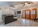 Spacious living room featuring tile floors, ceiling fans, and wooden shutters for a cozy and inviting space at 1814 N 89Th Ave, Phoenix, AZ 85037