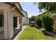 Well-maintained backyard with lawn, covered patio, mature trees, and playhouse at 18809 E Seagull Dr, Queen Creek, AZ 85142