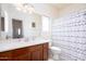 Bright bathroom featuring a wooden vanity, a large mirror, and a shower with a curtain at 18809 E Seagull Dr, Queen Creek, AZ 85142