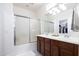 Clean bathroom with a double vanity, shower with glass door, and a walk-in closet at 18809 E Seagull Dr, Queen Creek, AZ 85142